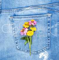 bouquet of flowers on the back pocket of blue jeans