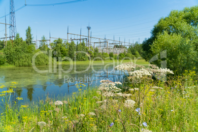 Power station near the pond. Power lines.