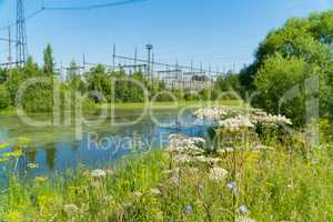 Power station near the pond. Power lines.