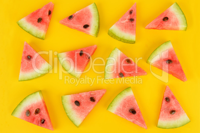 Sliced ripe watermelon on a bright yellow background. Flat lay,