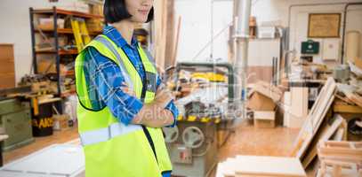 Composite image of female architect standing with arms crossed against grey background