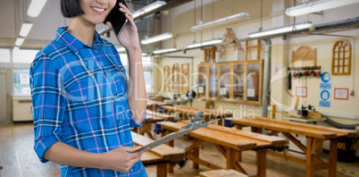 Composite image of female architect talking on mobile phone