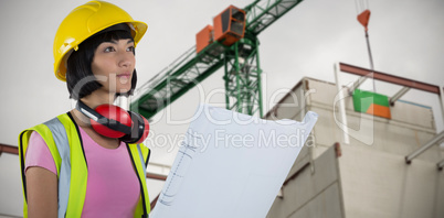 Composite image of female architect holding blueprint against white background