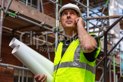 Male Builder Foreman Architect on Building Site Using Phone and