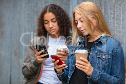Interracial Mixed Race Girl Teenagers Using Smart Phones Drinkin