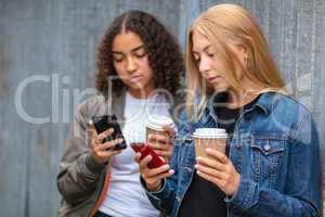 Interracial Mixed Race Girl Teenagers Using Smart Phones Drinkin