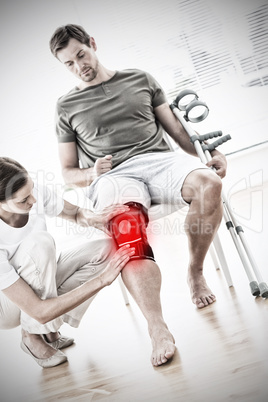 Composite image of physiotherapist checking man with crutches