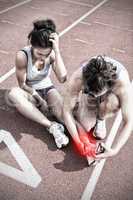 Composite image of woman caring about runner with sports injury