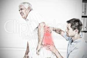 Composite image of male physiotherapist examining senior mans back