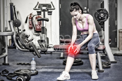 Composite image of healthy woman with an injured knee sitting in gym