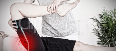 Composite image of masseuse stretching the right leg of a young woman