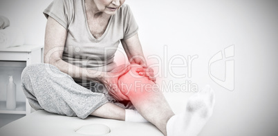 Composite image of senior woman with her hands on a painful knee