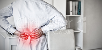 Composite image of casual businessman touching his sore back
