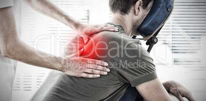 Composite image of physiotherapist giving massage to man