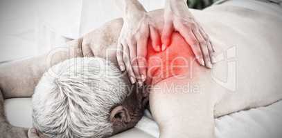 Composite image of therapist massaging back of senior man