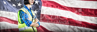 Composite image of female architect standing with arms crossed against grey background