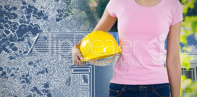 Composite image of woman holding hard hat against grey background