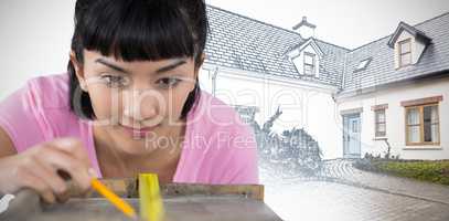 Composite image of woman measuring wooden plank with tape measure