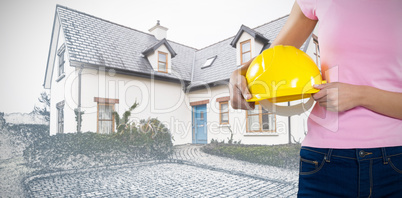 Composite image of woman holding hard hat against grey background