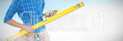 Composite image of female architect holding measuring equipment against grey background