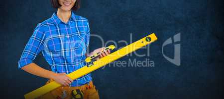 Composite image of female architect holding measuring equipment against grey background