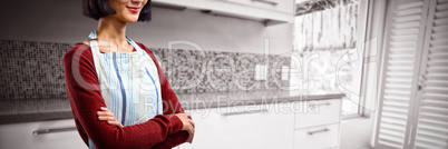 Composite image of waitress in spectacles standing with arms crossed against white background