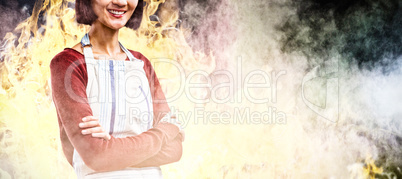 Composite image of smiling waitress standing with arms crossed against white background