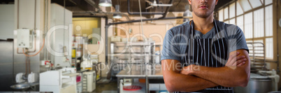 Composite image of male waiter standing with arms crossed