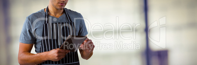 Composite image of male waiter using digital tablet