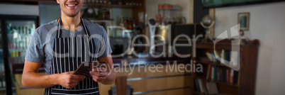 Composite image of male waiter holding digital tablet