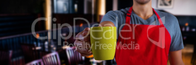 Composite image of male waiter holding coffee mug