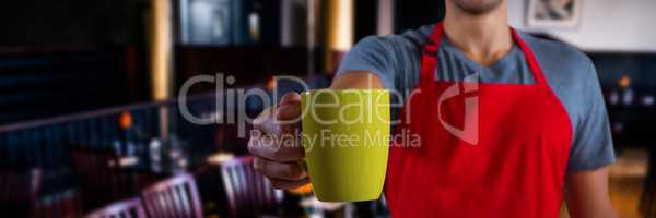 Composite image of male waiter holding coffee mug