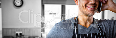 Composite image of male waiter talking on mobile phone