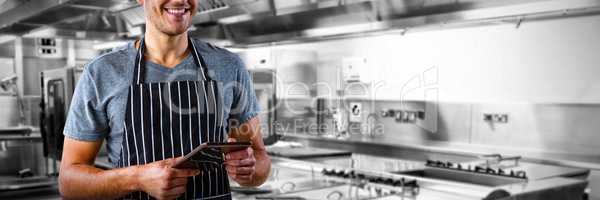 Composite image of male waiter using digital tablet