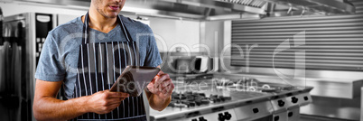 Composite image of male waiter using digital tablet