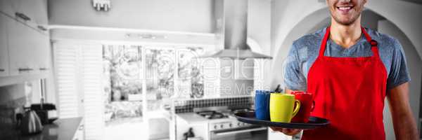 Composite image of male waiter holding tray with coffee mug