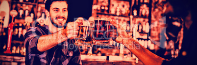 Two young men toasting their beer mugs