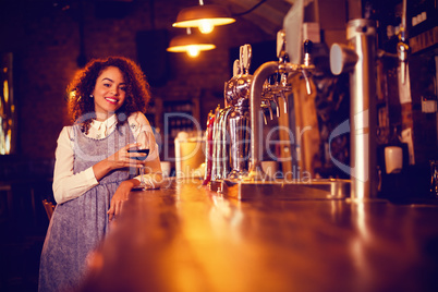 Portrait of young woman having wine at counter