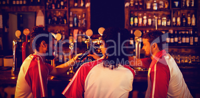 Group of male friends toasting beer bottles