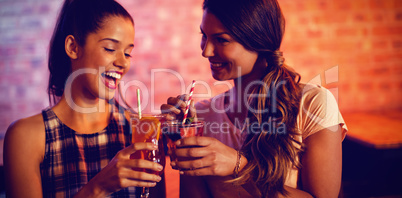 Two young women having cocktail drinks