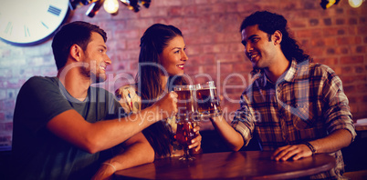 Young friends toasting beer mugs