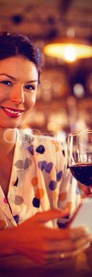 Portrait of young woman using mobile phone while having wine Portrait of young woman using mobile phone while having wine