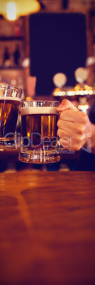 Two young men toasting their beer mugs