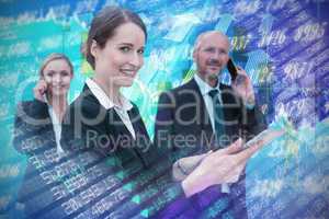 Composite image of businesswoman using tablet while colleagues talking on phone in background