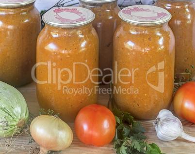 Canned squash caviar with vegetables in glass jars.