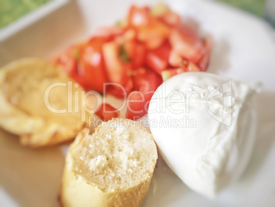 Homemade caprese salad with mozzarella cheese, chopped tomatoes and sliced bread