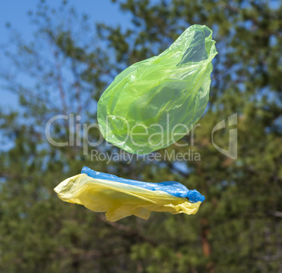 empty plastic bags fly through the green meadow