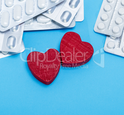 different pills in a package and two red hearts