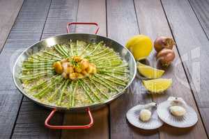 Paella with scollops and asparagus in traditional pan