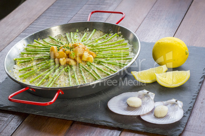 Paella with scollops and asparagus in traditional pan